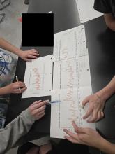 table top with 4 graphs and students pointing